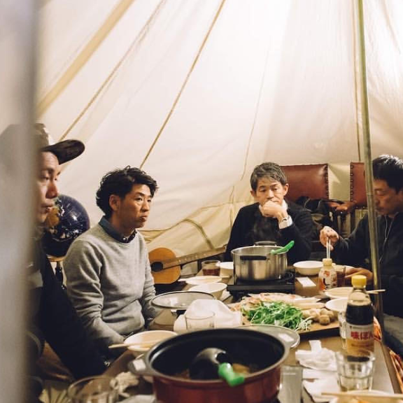 男性たちがグランピングテントのなかでまったりしている